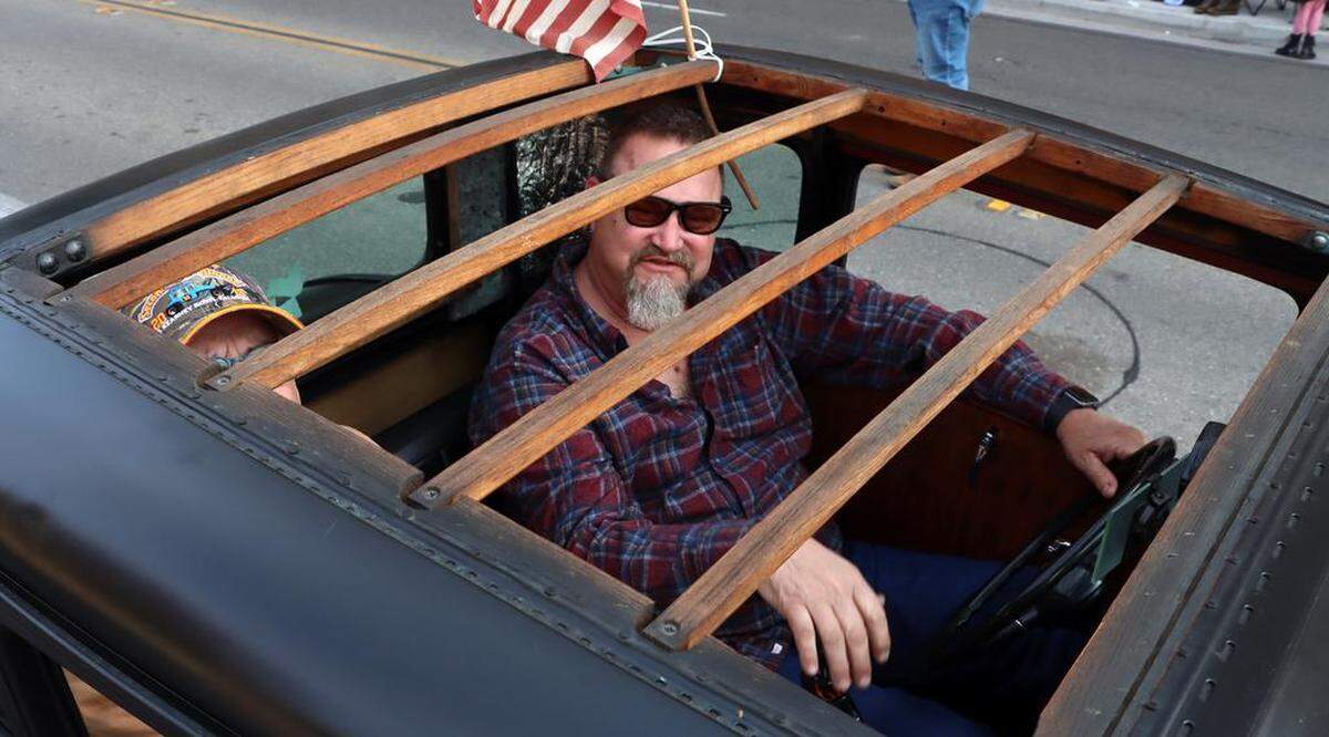 A man peers out from his hot rod car during the Veterans Day Parade through downtown Fresno on Nov. 11, 2022.