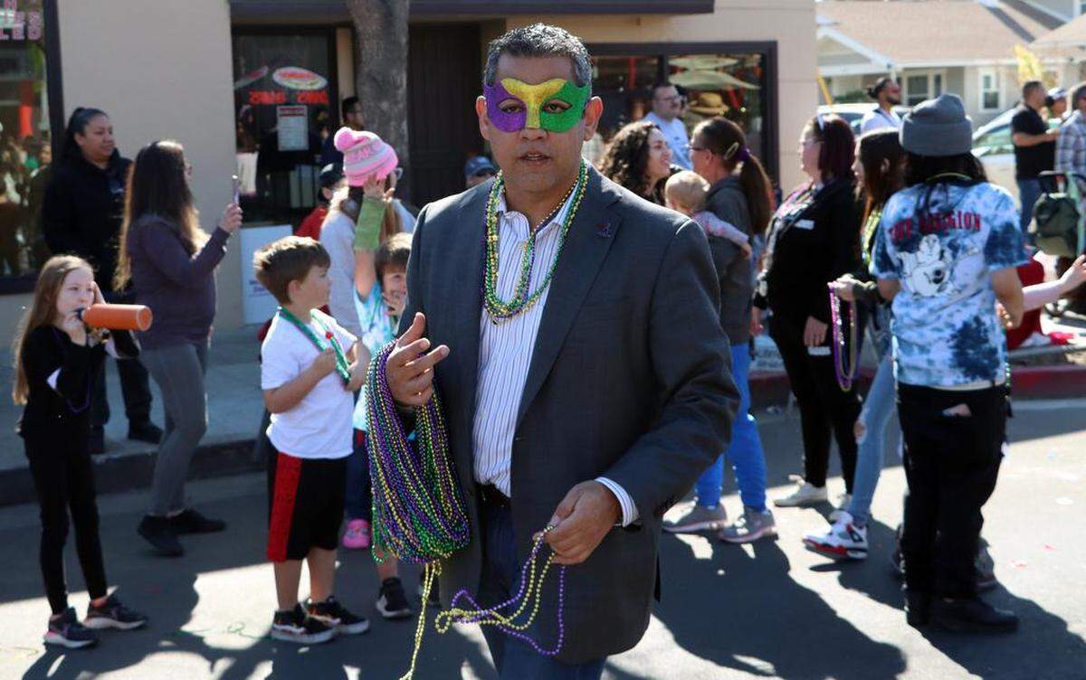 Fresno City Councilmember Miguel Arias throws beads at spectators during the 25th annual Mardi Gras Parade in the Tower District on Feb. 19, 2023.
