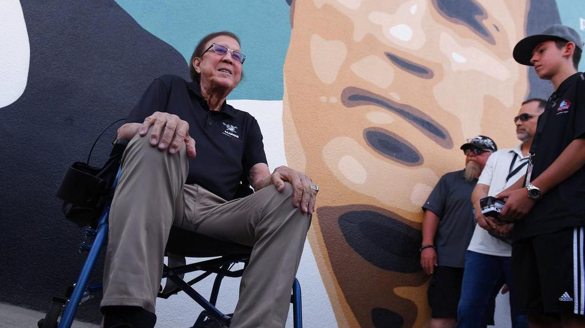 Tom Flores, left, poses for photos in front of the mural depictng him during the ‘Welcome Home’ Celebration held Saturday, Sept. 18, 2021 in downtown Sanger.