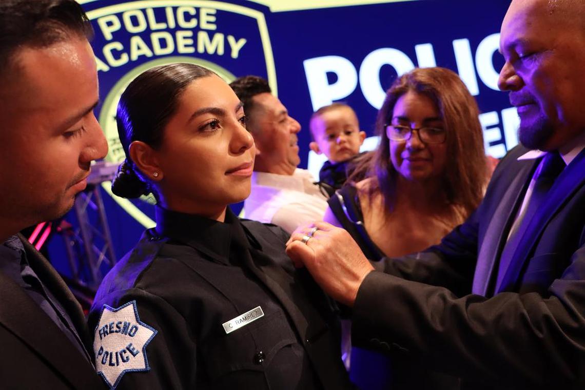 Cristal Ramírez, who joins the Fresno Police Department, gets her badge pinned on during the police academy completion ceremony at CrossFit Church.