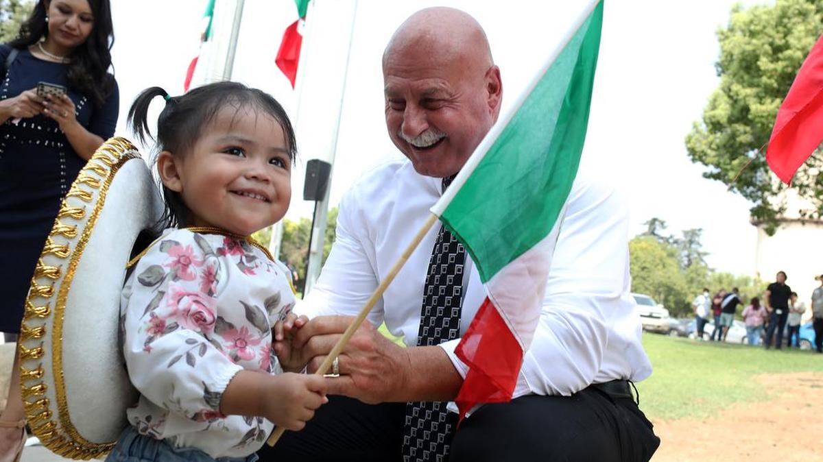 Fresno Mayor Jerry Dyer greets 1½-year-old Elena Flores during a Mexican Independence Day celebration at Unity Park on Sept. 15, 2021.