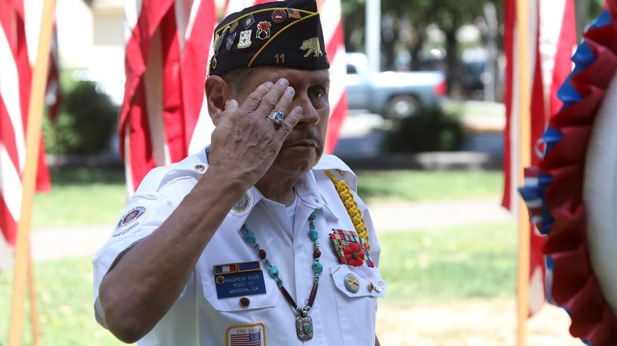 Andrew Ríos of American Legion Post 11 salutes after placing a wreath at a military monument in Mader’'s Courthouse Park on May 31, 2021.
