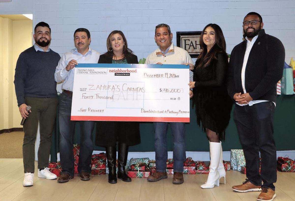 Humberto ‘Beto’ and Gaby Gómez, owners of Zamora’s Carnitas Restaurant, got a $40,000 check from Neighborhood Industries and the Fresno Area Hispanic Foundation during a posada for the restaurant owner and workers on Dec. 19, 2022. Left to right: Ricky Bravo of Neighborhood Industries, the Gómez couple, Fresno City Councilmember Miguel Arias, Dora Westerlund of the foundation, and Fresno City Council President Nelson Esparza.