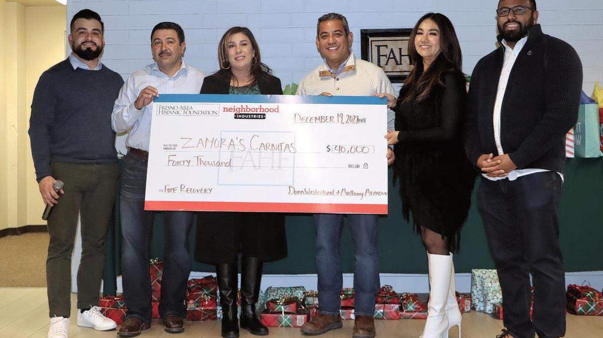 Humberto ‘Beto’ and Gaby Gómez, owners of Zamora’s Carnitas Restaurant, got a $40,000 check from Neighborhood Industries and the Fresno Area Hispanic Foundation during a posada for the restaurant owner and workers on Dec. 19, 2022. Left to right: Ricky Bravo of Neighborhood Industries, the Gómez couple, Fresno City Councilmember Miguel Arias, Dora Westerlund of the foundation, and Fresno City Council President Nelson Esparza.