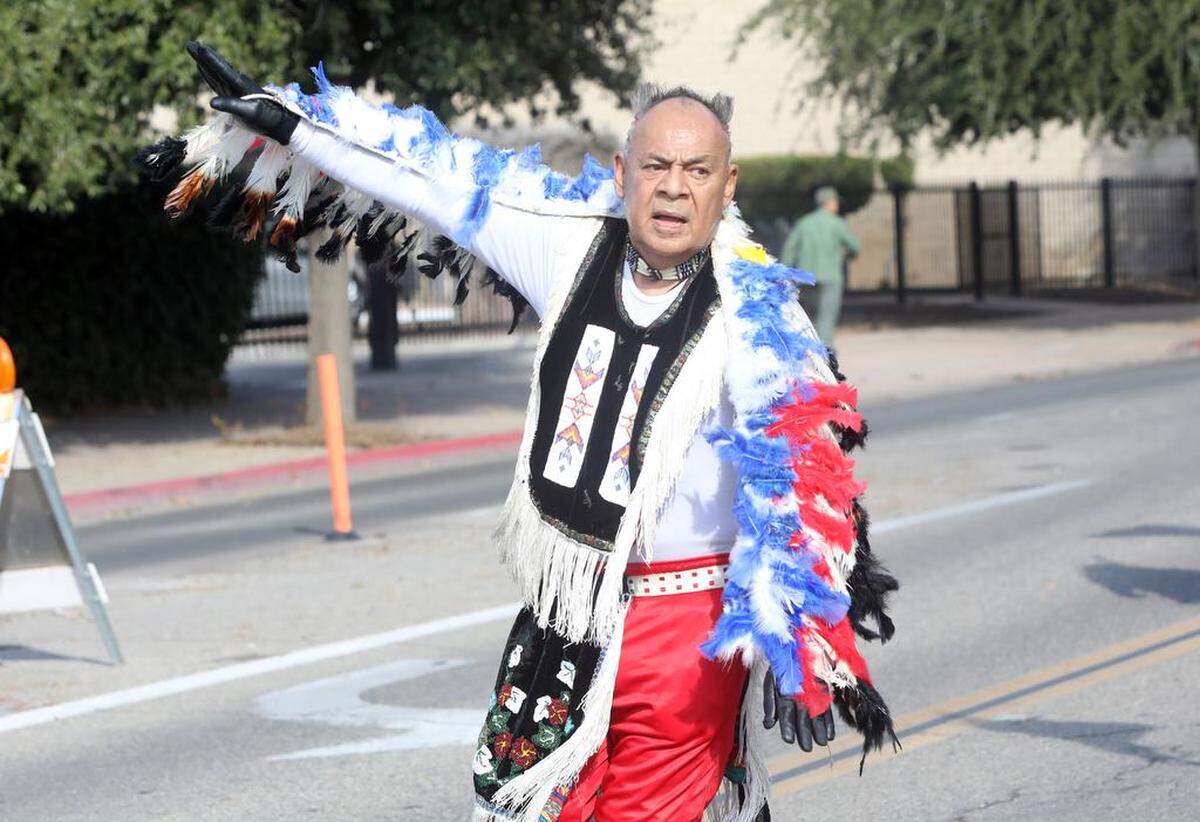 An Indigenous flag group member dances during the Fresno Veterans Day Parade in downtown Fresno on Nov. 11, 2022.