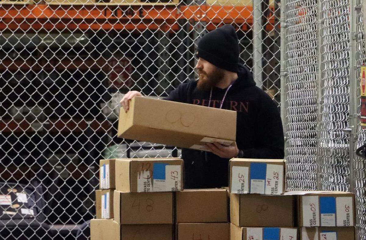 A Fresno County Elections worker handles boxes of ballots at the start of a recount in the state Senate District 16 race between winning incumbent Melissa Hurtado and Republican challenger David Shepard at a county warehouse on Dec. 20, 2022. Officials expect the recount to take five days or more to complete.