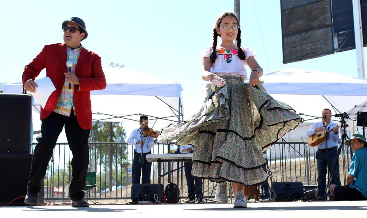 Teatro La Familia Feliz member Everardo Pedraza and Avani Pedraza dance to the music of Los Originarios del Plan during a June 13, 2021 pop up performance at the Madera fairgrounds.