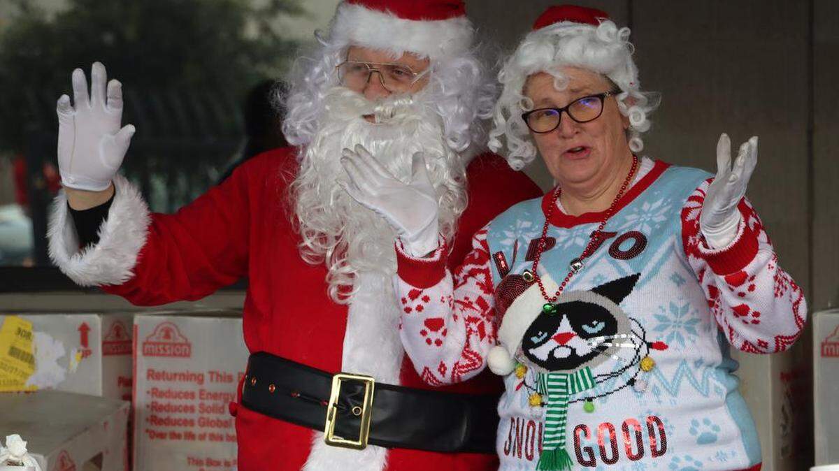 Santa and Mrs. Claus wave during the 25th annual Navidad en el Barrio at the Bautista Medical Group parking lot in downtown Fresno on Dec. 17, 2022.