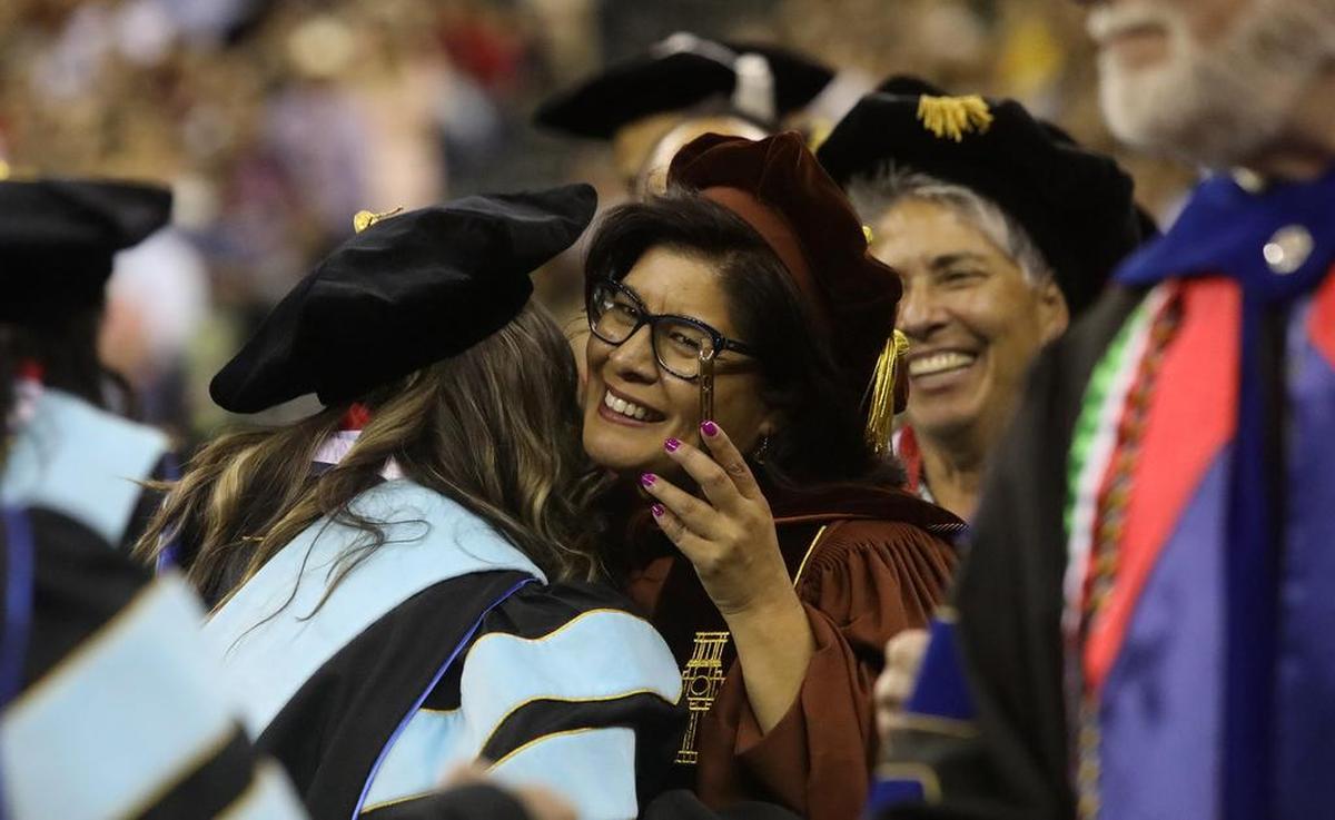 Un profesor de Fresno State felicita a uno de los graduados de doctorado en la Celebración de Graduación Chicano/Latino del 46.º aniversario de Fresno State en Save Mart el 21 de mayo de 2022.