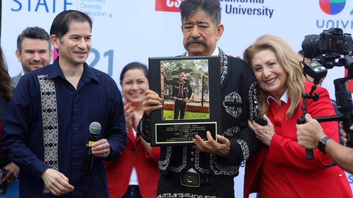 Chuy Chávez, leader of the longtime band Los Originales de San Juan, was honored as the ambassador of the seventh Fería de la Educación at Fresno State on Oct. 22, 2022. Fresno State President Saúl Jiménez-Sandoval and Univision show hostess Lupita Lomelí presented him with a plaque.