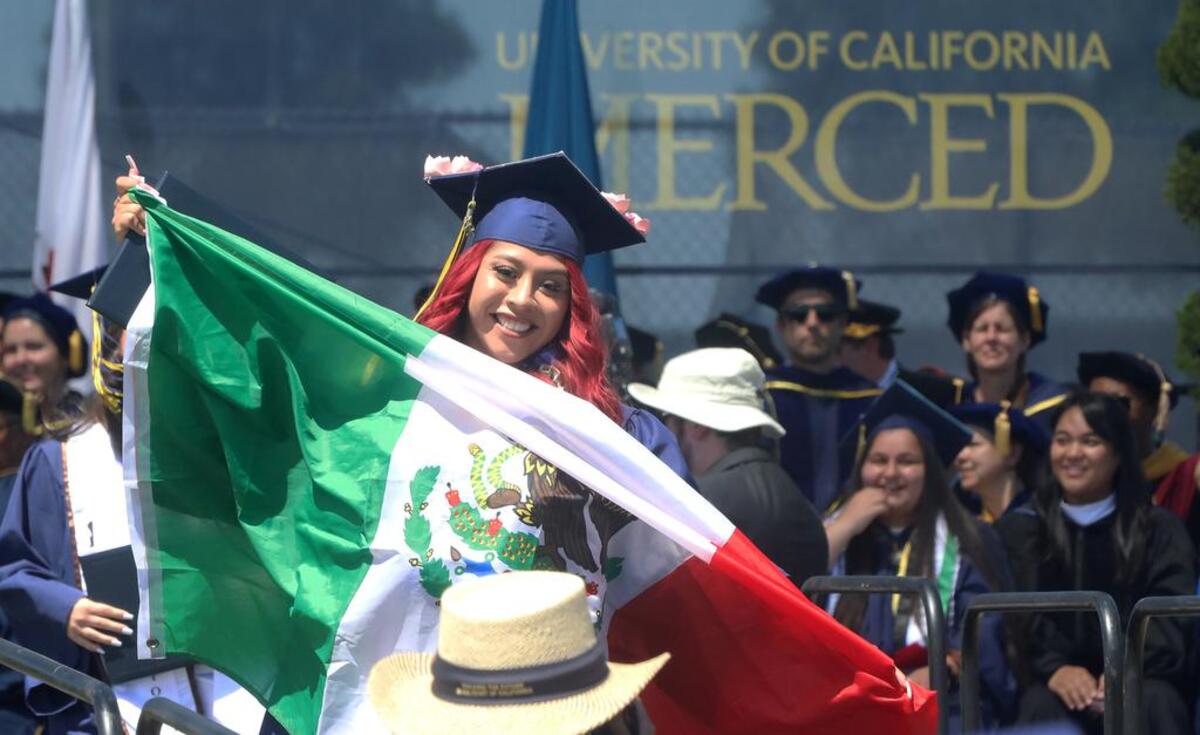 UC Merced graduate Anahi Flores-Morales displays the Mexican flag during the May 15, 2022 commencement.