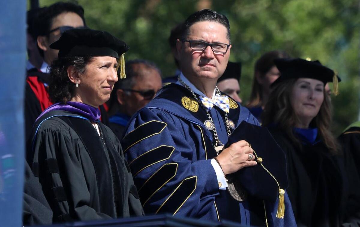 UC Merced Chancellor Juan Sánchez Muñoz and former UC Regent Cecilia Estolano listen to the national anthem at the start of the May 15, 2022 commencement.