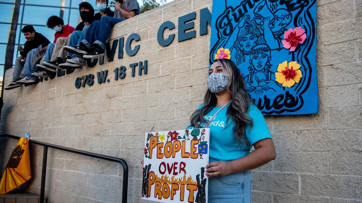 La gente posa para fotos frente a una pancarta afuera del Centro Cívico de Merced durante la manifestación Fund Our Futures en Merced, California, el lunes 18 de octubre de 2021. La manifestación se llevó a cabo para instar a la Ciudad de Merced a invertir $3 millones de los $27 millones del dinero de ayuda federal de la Ley del Plan de Rescate Estadounidense, destinados a empleos para jóvenes e ingresos directos.