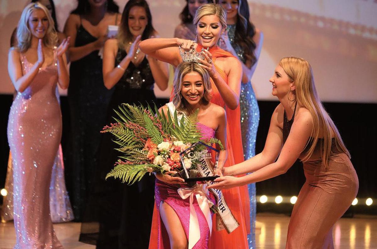 Miss California Volunteer 2021 Caroline Azer of San Diego is crowed by Christine Williamson, Miss Tennessee 2018 and a judge, during the July 10, 2021 pageant at the Clovis Veterans Memorial Auditorium.
