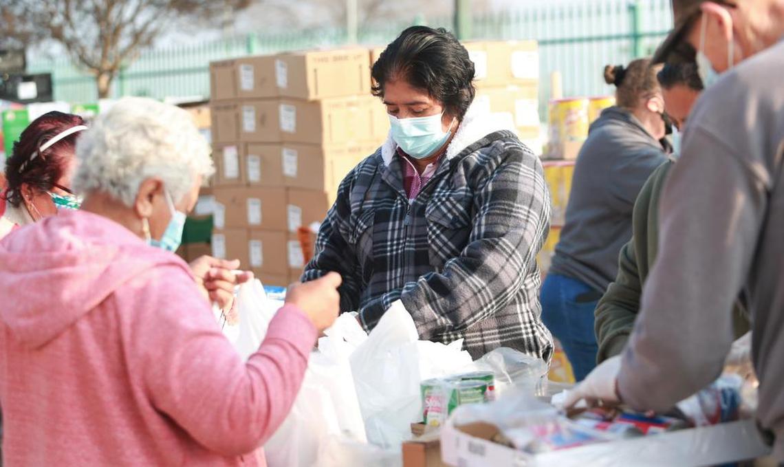 Orange Cove residents and volunteers help bag food items at the Fresno EOC food distribution site on Jan. 18 at the community center.