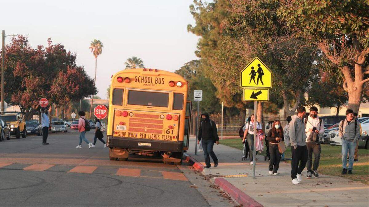 A crossing guard outside of Tehipite Middle School on Nov. 12. The 93701 zip code, low in vaccination rates, is home to the school.