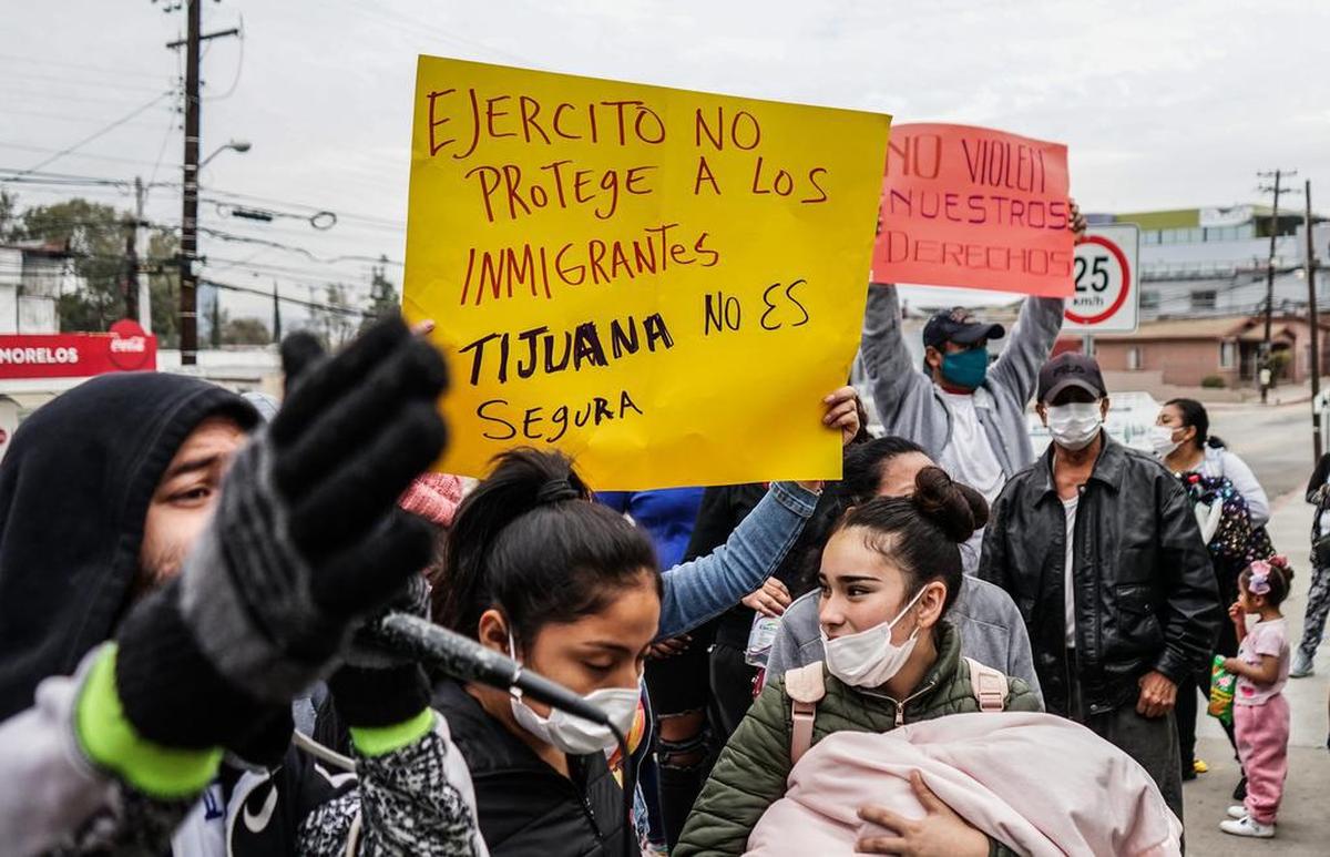 Migrantes de diversas nacionalidades se manifiestan por la falta de seguridad durante su paso por México, en un cuartel militar, el 21 de diciembre de 2021, en la ciudad de Tijuana, en Baja California.