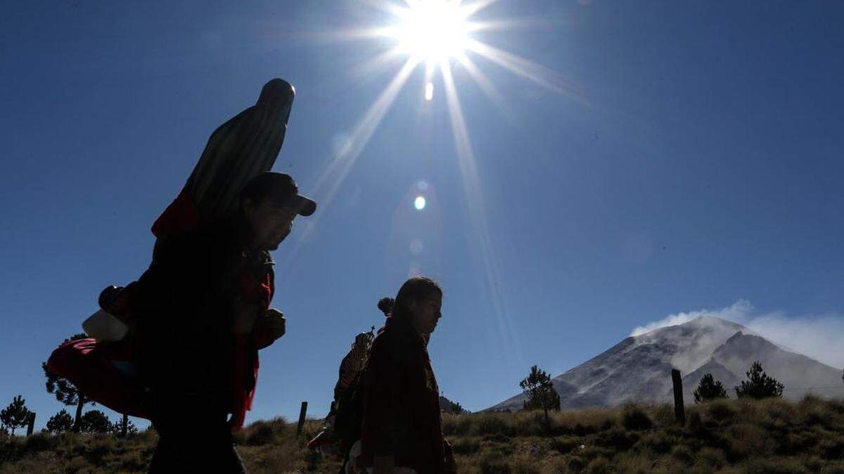 Peregrinos de varias comunidades caminan rumbo a la capital del país, hoy en la cercanías del Volcán Popocatépetl, hoy, en la zona de Paso de Cortés, en el estado de Puebla. Fieles mexicanos iniciaron este viernes la peregrinación hacia la Basílica de Guadalupe de Ciudad de México para conmemorar a la Virgen tras dos años de restricciones por la pandemia de COVID-19.