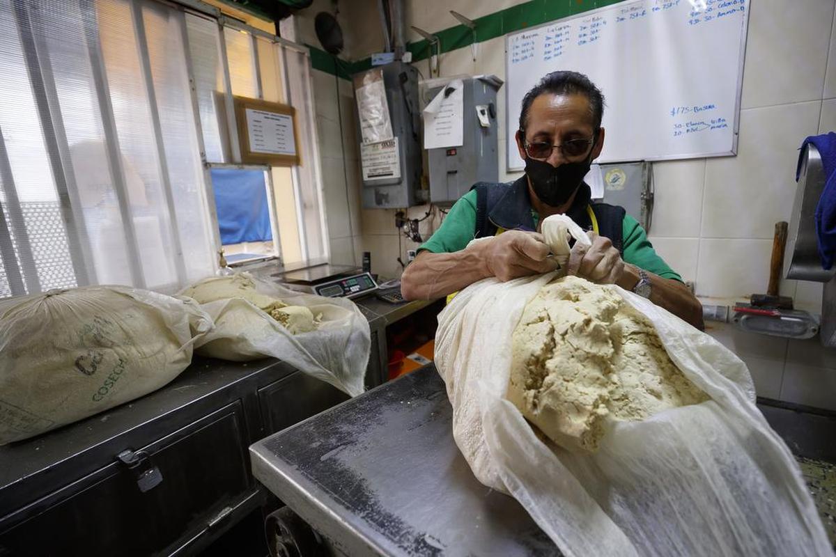 A worker packs corn dough that is used for making corn tortillas. Tortilla makers in México have been hit by inflation and a shortage of corn.