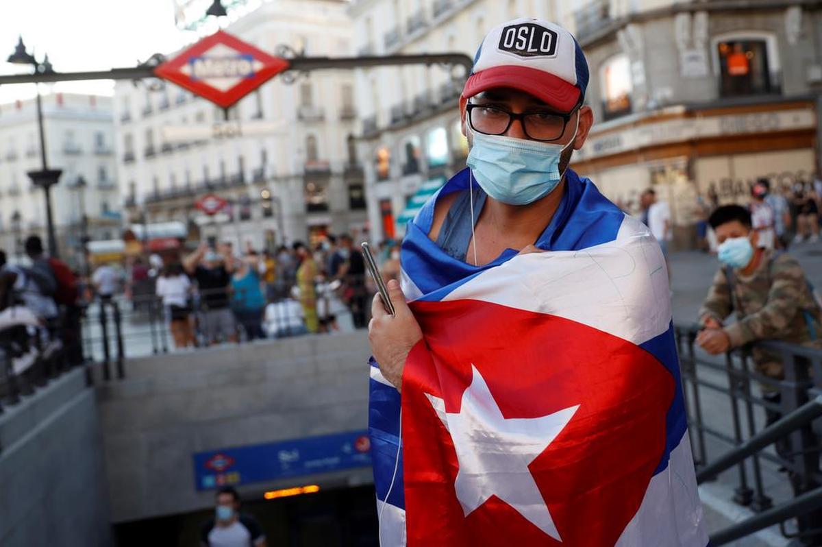 Varias personas participan en la concentración "Por una Cuba libre" en la Puerta del Sol, este lunes en Madrid.