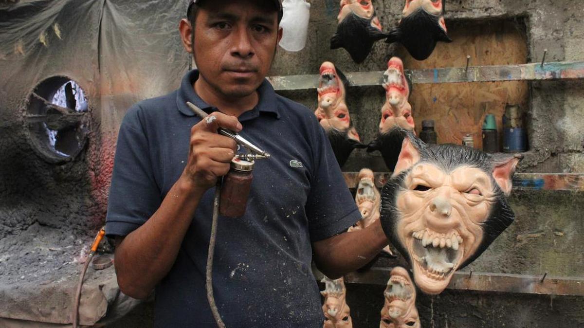 A Mastermanía worker shows a Day of the Dead mask at the shop in Puebla.