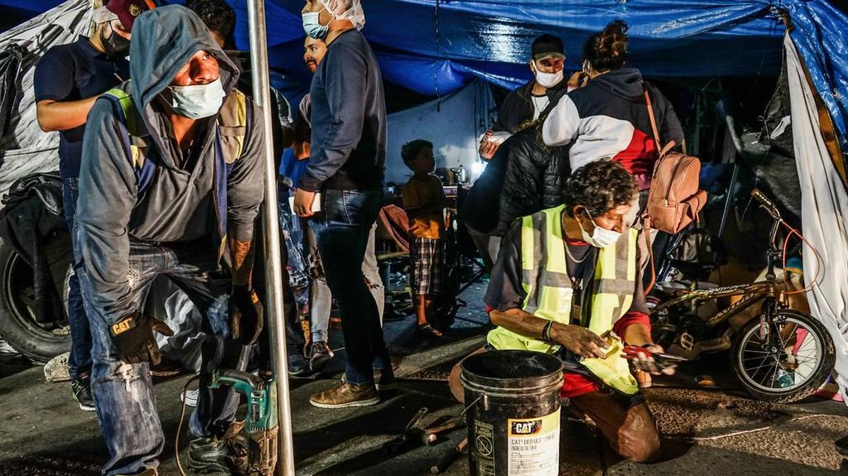 Autoridades instalan vallas metálicas en la explanada de El Chaparral, en la ciudad de Tijuana, Baja California. Los más de mil migrantes que pernoctan en un campamento improvisado en Tijuana desde hace meses fueron sorprendidos el jueves en la noche cuando las autoridades instalaron una valla alrededor de la explanada de El Chaparral.