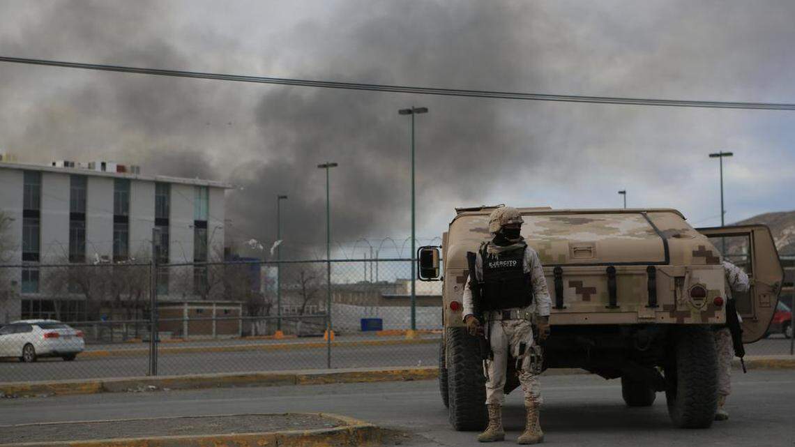 Mexican army troops guard the grounds outside a federal prison near Ciudad Juárez where gunmen in armored vehicles showed up and fired, leaving at least 14 dead and 20 escaped convicts.