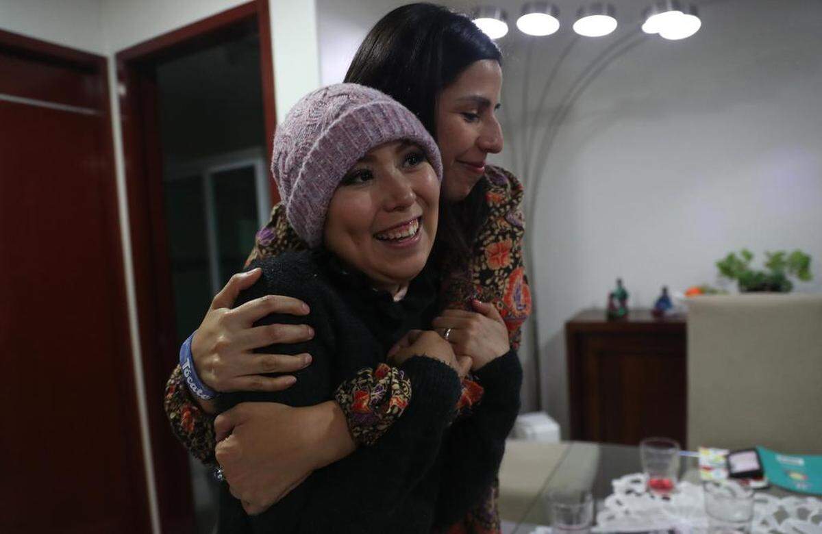 Lorena Estrada (frente) es abrazada por Sandra Monrroy (atrás) ambas con cáncer de mama.