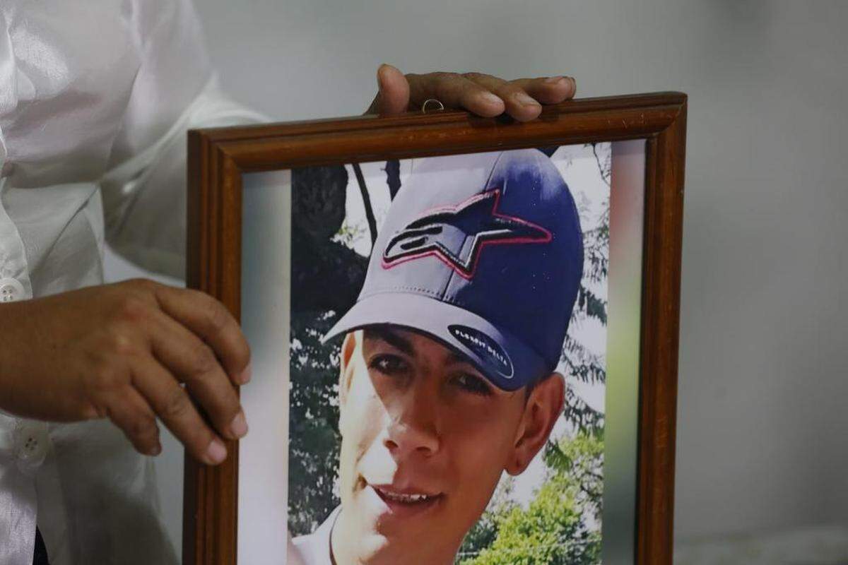 Guadalupe Ayala Contreras, with Families United for Our Missing Ones in Jalisco, holds a portrait of her son, Alfredo Ezequiel Campos, during an interview.
