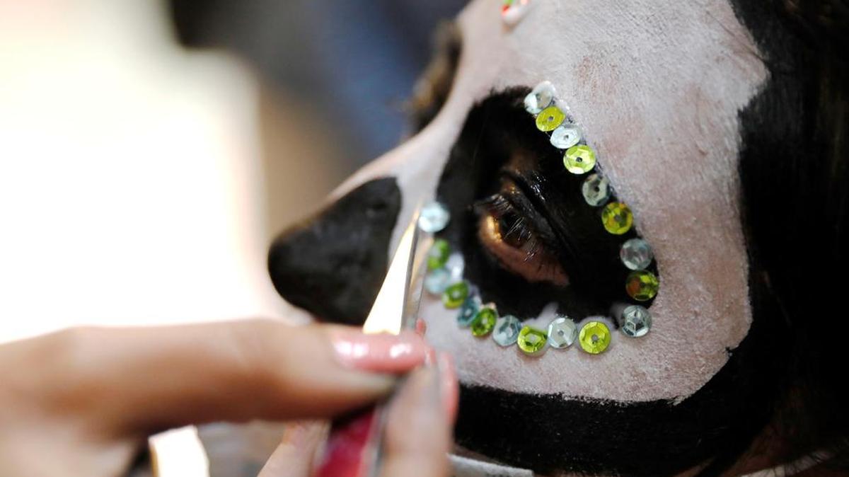 Un niño es pintado como Catrina, uno de los símbolos más característicos de la cultura mexicana, durante una conmemoración del Día de Muertos en Bogotá.