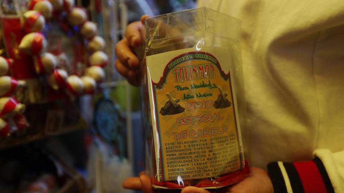 Una persona muestra un amuleto en el Mercado de Sonora, el 31 de diciembre de 2021, en Ciudad de México. Desde velas que dan abundancia, pasando por rituales con incienso hasta un "amarre" para encontrar el amor, todo es válido en el Mercado Sonora, uno de los puntos con mayor mística en la capital mexicana, y en donde la gente se agolpa a finales de año para que, aunque sea con magia, sus aspiraciones para 2022 se puedan cumplir.