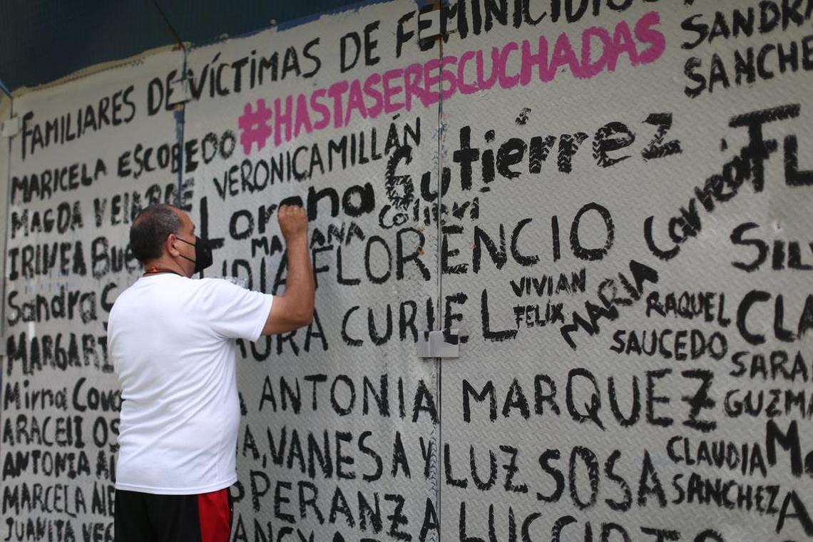 A supporter paints names of activist women.