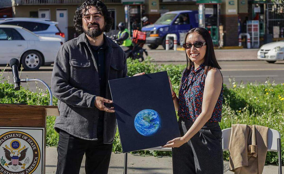 El artista y creador del mural bicentenario, Iván Arévalo, obsequia un cuadro a la científica y astronauta mexicana Katya Echazarreta, durante un acto protocolario el 8 de febrero de 2023 en Tijuana, Baja California.