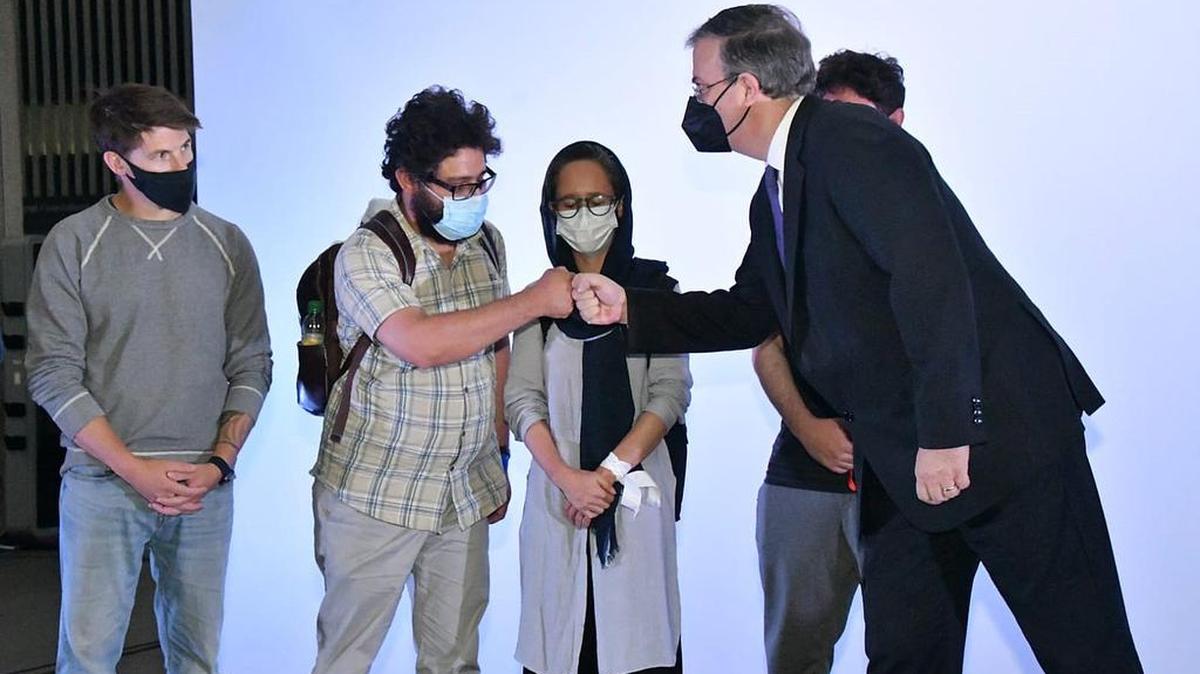 Fotografía cedida hoy por la Secretaria de Relaciones Exteriores (SRE) de México que muestra al canciller Marcelo Ebrard mientras recibe a ciudadanos afganos que llegaron al Aeropuerto Internacional de la Ciudad de México.