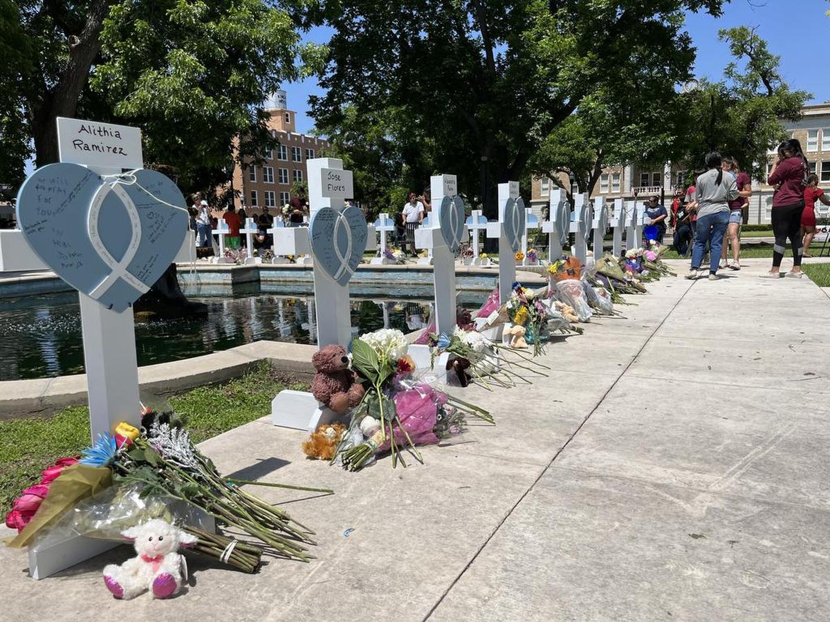 Personas visitan hoy las cruces instaladas en memoria de las 21 víctimas asesinadas el martes en la masacre de la escuela primaria Robb, en la plaza central de Uvalde, Texas.