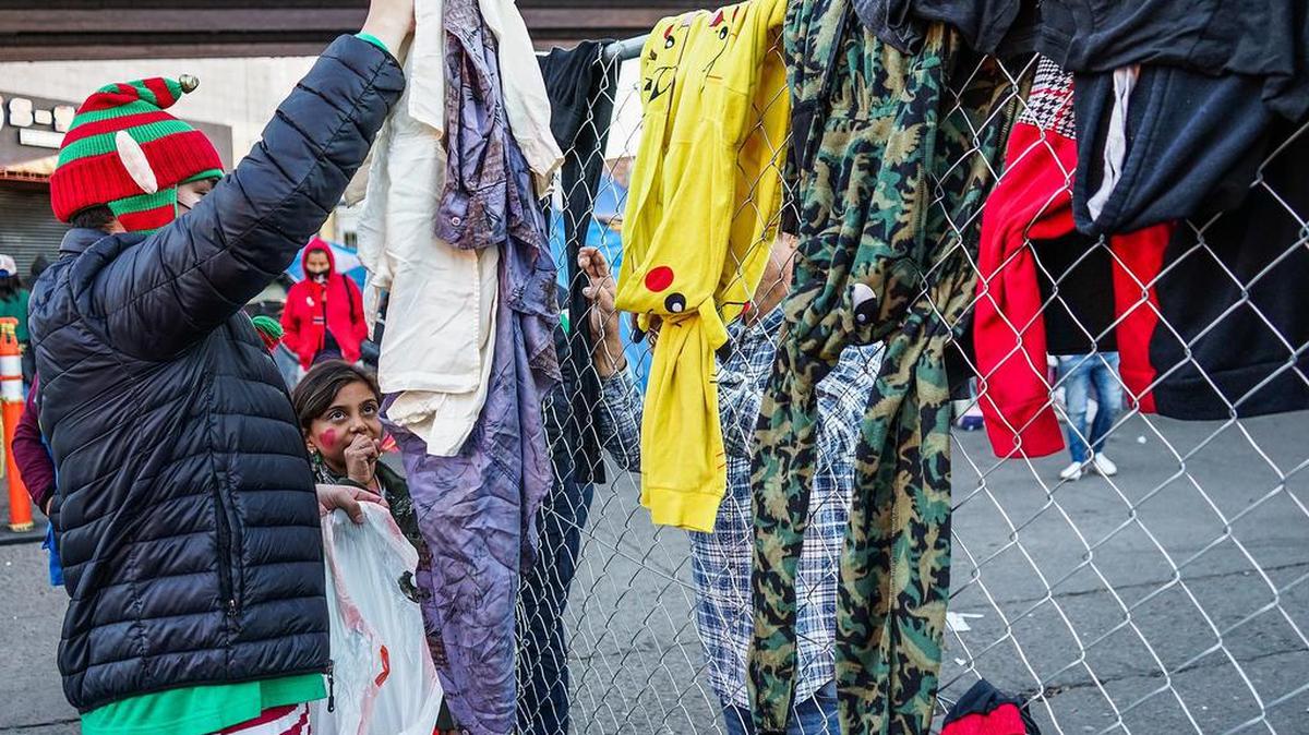 A man in Christmas attire gives away clothes at a shelter in Tijuana on Christmas Eve.