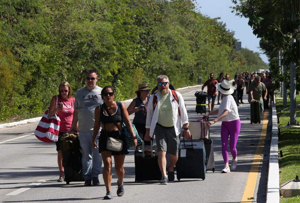 Turistas caminan hacia el Aeropuerto Internacional de Cancún. Por disputas violentas entre taxistas y conductores de plataformas como Uber, la embajada de Estados Unidos en México emitió una alerta de seguridad para los ciudadanos estadounidenses que visitan o radican en Cancún, Quintana Roo, al sur de México.