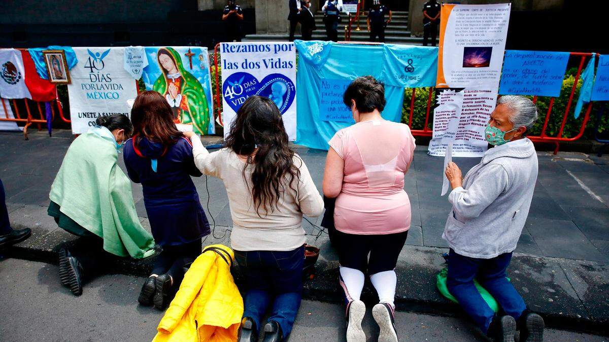 MEX786. CIUDAD DE MÉXICO (MÉXICO), 07/09/2021.- Un grupo de mujeres en contra del aborto rezan frente a carteles de protesta “pro-vida” y religiosos hoy, afuera de la Suprema Corte de Justicia de la Nación, en la Ciudad de México. La Suprema Corte de la Justicia de la Nación (SCJN) de México declaró este martes inconstitucional la penalización de las mujeres que abortan en la primera etapa del embarazo y reconoció el derecho a decidir en un fallo histórico. Por unanimidad, los ministros del pleno de la SCJN invalidaron el artículo 196 del código penal del norteño estado de Coahuila que imponía de uno a tres años de cárcel “a la mujer que voluntariamente practique su aborto o a la persona que le hiciere abortar con el consentimiento”. EFE/ Carlos Ramírez