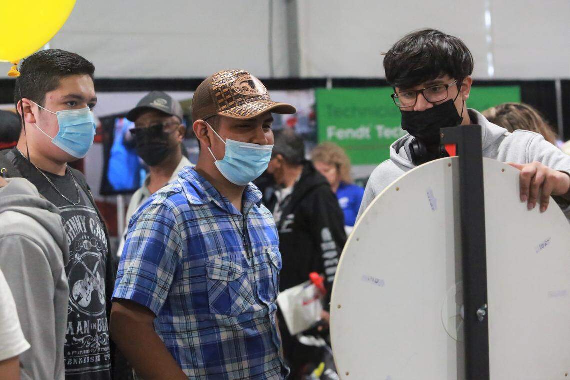 Los estudiantes de Mendota High School Jesús Figueroa, Tomás Pérez y Edgar Larreynaga se detuvieron en el stand de la Universidad Politécnica del Estado de California, Pomona, dentro de la carpa de carreras y educación agrícola en la World Ag Expo, el martes 8 de febrero de 2022.