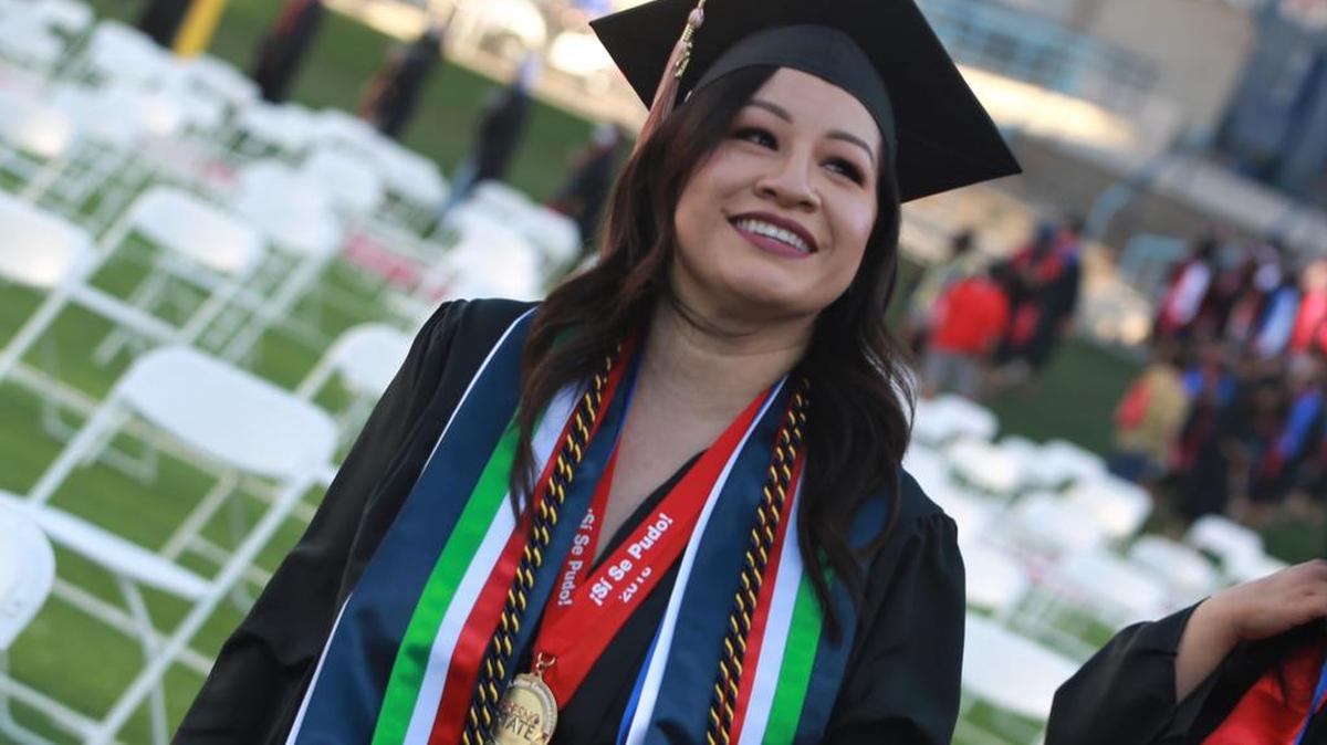 A Fresno State graduate glances at the stands during the May 14, 2021 evening commencement at Bulldog Stadium.